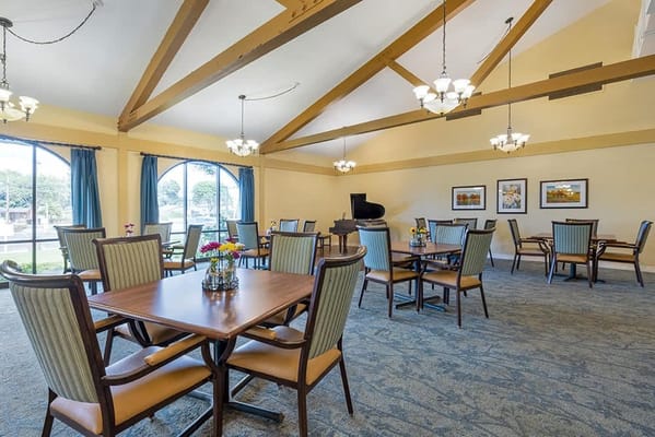 Common area with tables and chairs in a well-lit room
