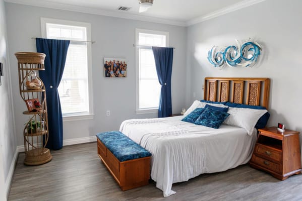 Bright bedroom with a bed, seating area, and decorative accents