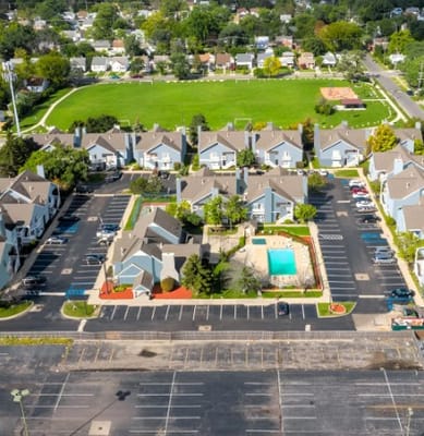 Aerial view of a senior living community with green space and pool
