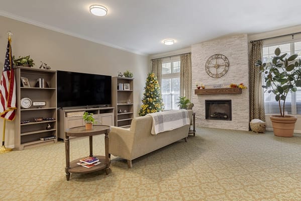 Bright common area with a cozy fireplace and holiday decor