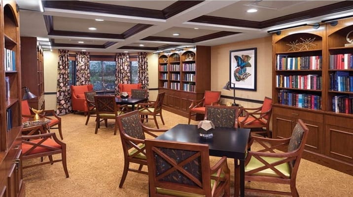 Cozy library with bookshelves, seating, and tables