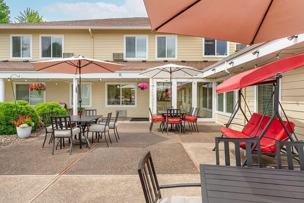 Patio with outdoor seating and umbrellas at a senior living facility