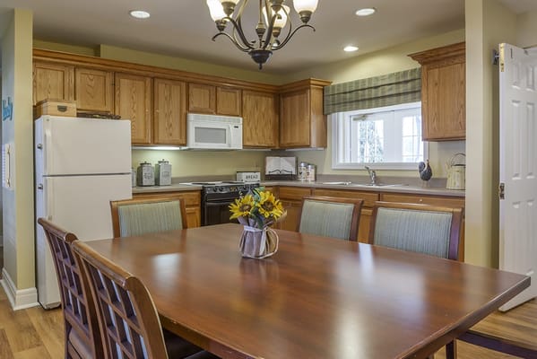 Bright kitchen area with wooden cabinets and dining table
