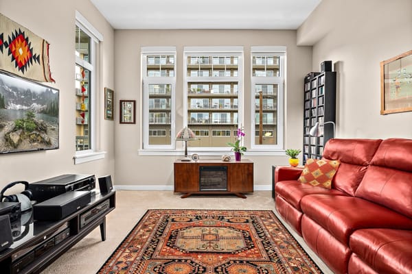 Bright interior living area with red couch and large windows