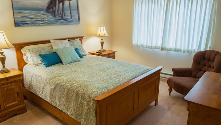 Comfortable bedroom with a cozy bed, lamps, and a sitting area