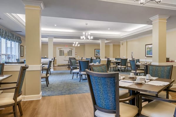 Bright dining room with tables set for residents
