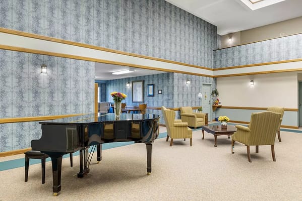 Bright interior common area with a piano and seating