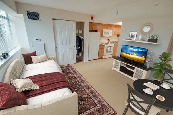 Living area with sofa, dining table, and kitchen in a senior apartment