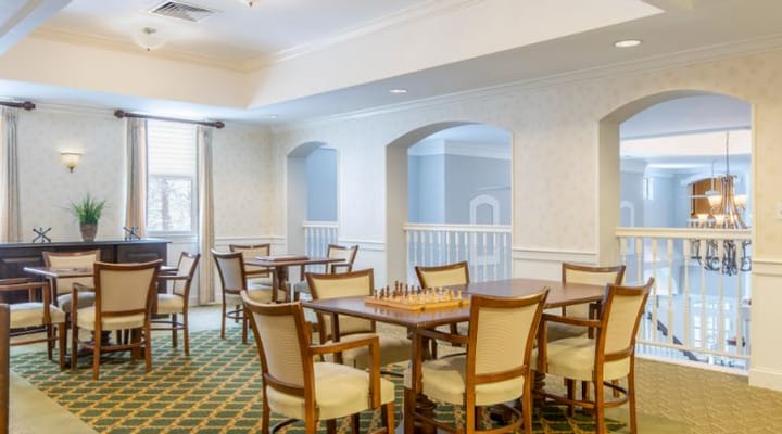 Common area with tables and chess set in a senior living facility