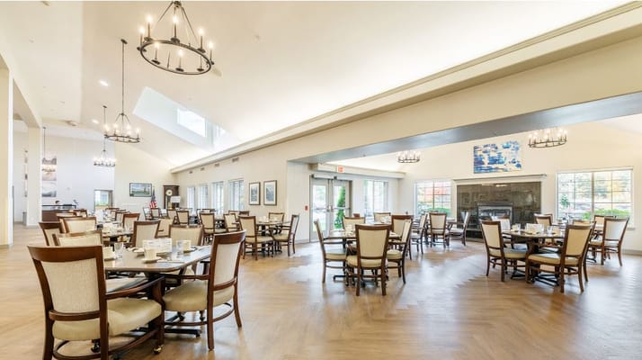 Spacious dining area with tables and chairs in a senior living facility