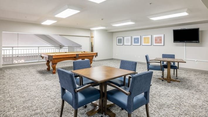 Spacious common area with a pool table and seating at Holiday Kittery Estates.