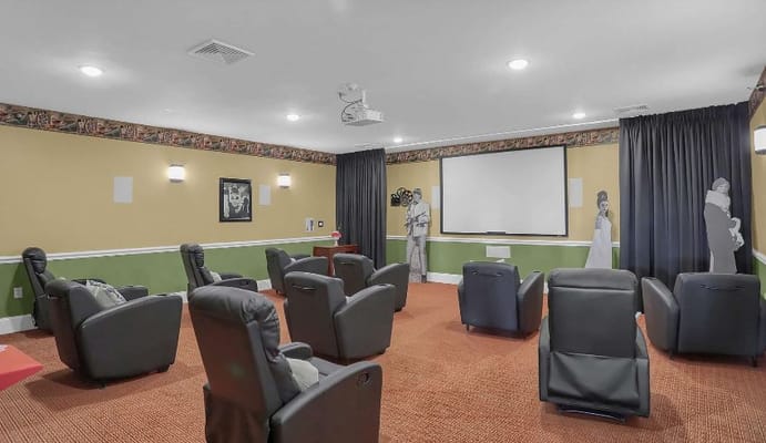 Theater room with reclining chairs and a large screen