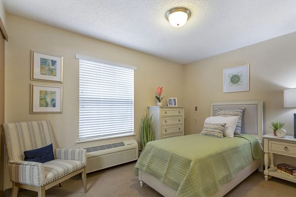 Cozy private resident room with a bed and chair