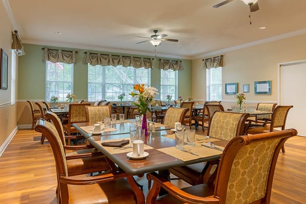 Bright dining room set for meals with floral centerpieces