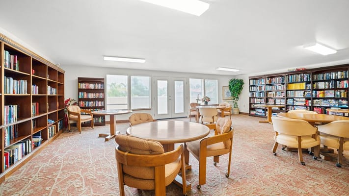 Cozy library space with bookshelves and reading tables at Mission Commons