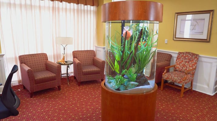 Fish aquarium surrounded by seating in lounge area.