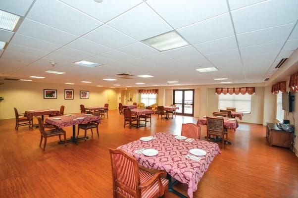 Brightly lit dining room with tables set for meals