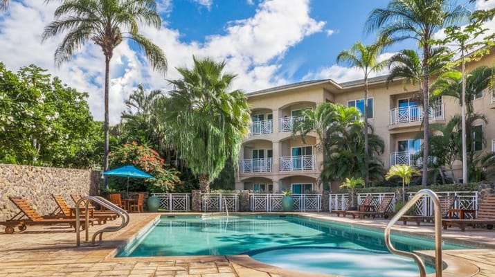 Outdoor pool area with lounge chairs and palm trees