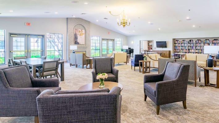 A bright common area with comfortable seating and a library