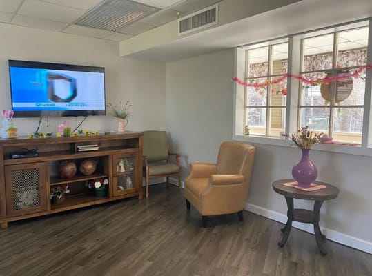 Lounge area with a TV, seating, and decorative plants