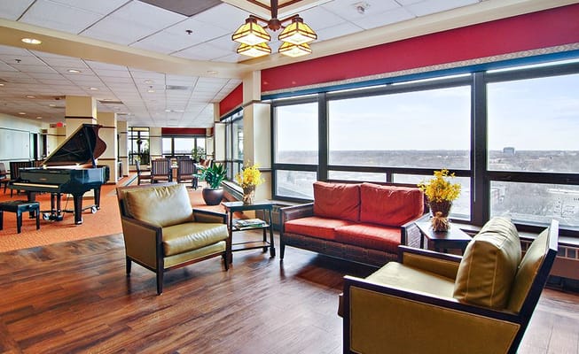 Bright common area with comfortable seating and piano