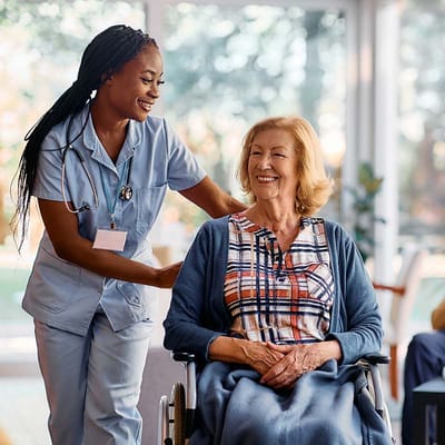A caregiver assisting a happy resident in a common area