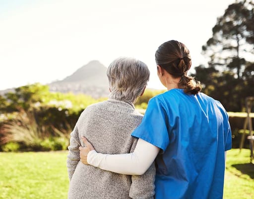 Senior resident with caregiver enjoying outdoor space