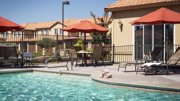 Outdoor pool area with lounge chairs and umbrellas