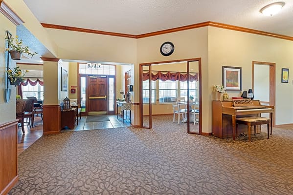 Interior view of a welcoming common area with seating and a piano