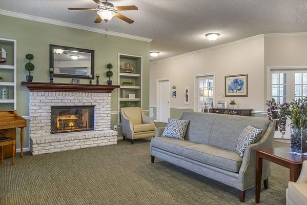 Interior of a cozy common area with seating and a fireplace