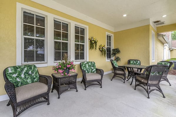 Outdoor seating area with tropical chairs and flower arrangements
