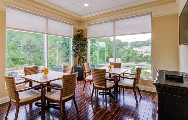 Bright dining area with tables overlooking green scenery