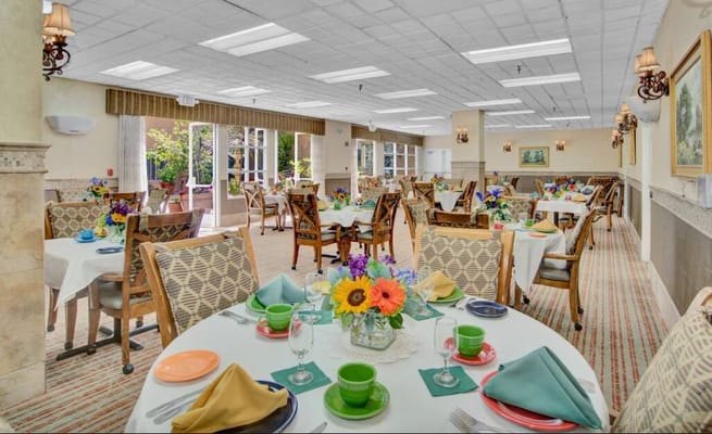 Bright dining room set for a meal with flowers and table settings
