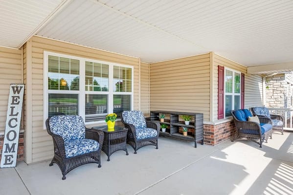 Outdoor seating area with welcome sign and flowers