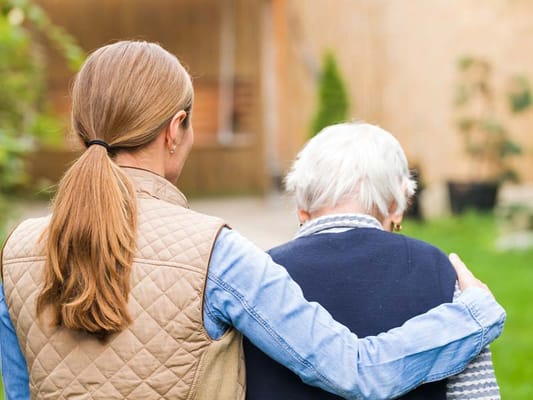 Caregiver and resident walking together outdoors