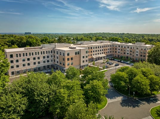 Aerial view of a senior living facility surrounded by greenery