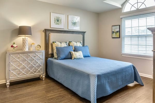Cozy private bedroom with a blue quilt and natural light