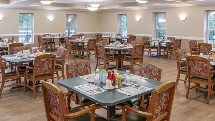 Dining room setup with tables and chairs arranged for meals
