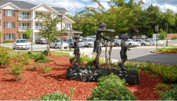 Sculpture of children playing in front of the facility