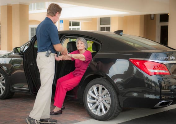 Staff assisting a resident getting out of a vehicle