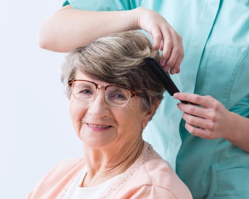 A resident receiving a hair styling treatment