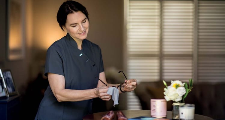Staff member adjusting eyeglasses in a cozy interior