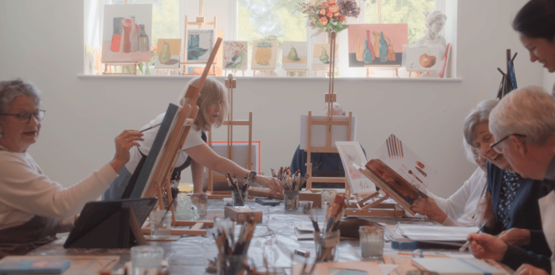Residents participating in a painting activity in a bright room