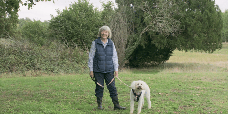 Resident walking a dog in a grassy area