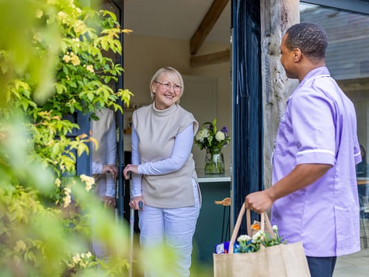 Staff member delivering groceries to a resident's home