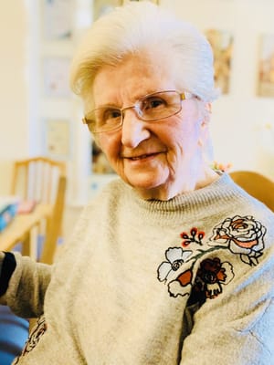 A smiling resident in a cozy interior setting