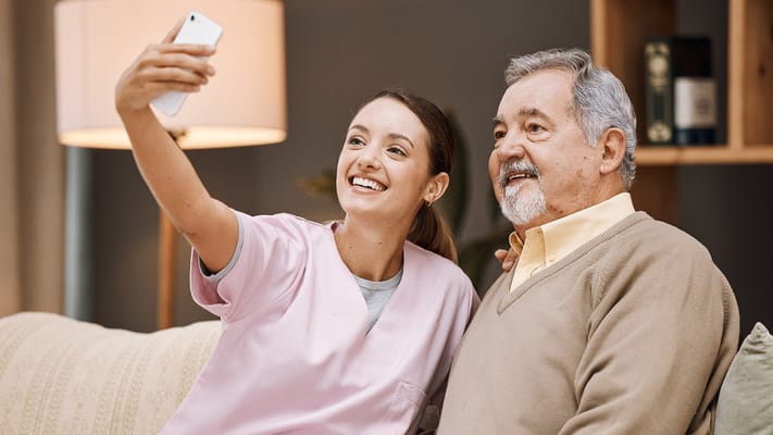 A caregiver and a resident taking a selfie together