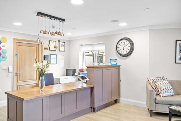 Bright reception area with a wooden desk and seating