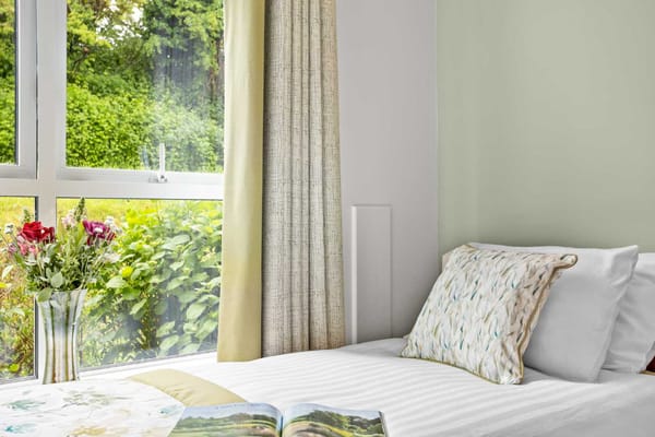 Cozy bedroom with a view of greenery and flowers