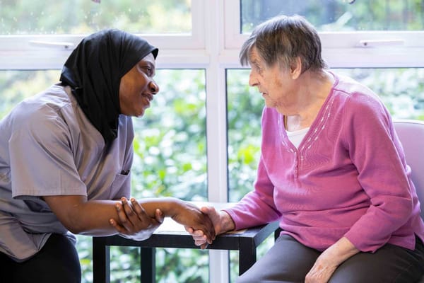 Staff member interacting with a resident in a cozy setting
